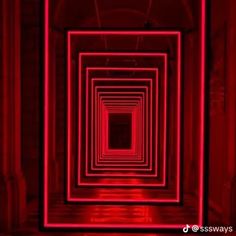 an empty room with red light coming from the ceiling and floor, in which there is a square pattern