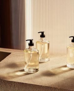 three soap dispensers sitting on top of a counter