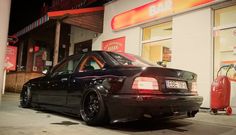 a black car parked in front of a bar