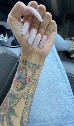 a person with a tattoo on their arm holding a white object in the middle of her hand