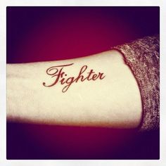 a woman's arm with the word fighter tattooed on it