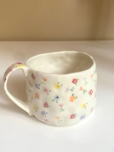 a white cup with flowers painted on it