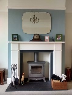 a living room with a fire place in the center and pictures on the wall above it