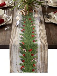 the table runner is decorated with red and white candy canes, pine cones, and greenery