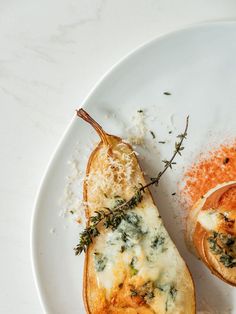 an eggplant stuffed with cheese and herbs sits on a plate next to some seasoning