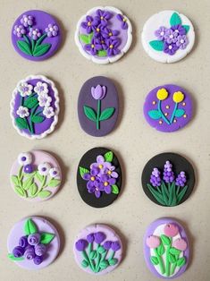 nine decorated cookies with flowers on them sitting next to each other in the shape of buttons