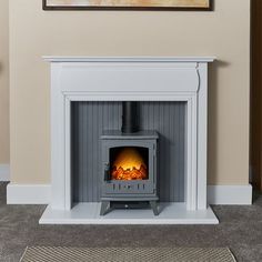 a fireplace with a wood burning stove in the middle and a painting on the wall above it