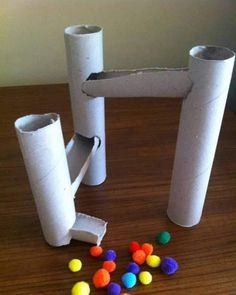 some toilet paper tubes are sitting on a table with candy balls in front of them