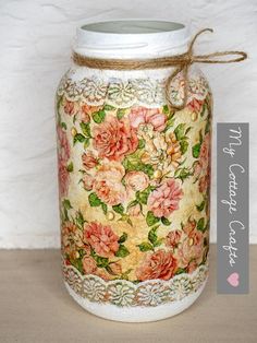 a jar with flowers painted on it sitting on a table