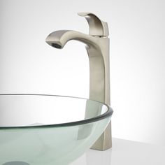 a glass bowl sink with a faucet and chrome finish on the side,