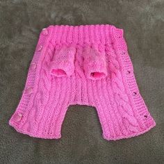 a pink knitted leg warmer sitting on top of a carpet