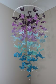 a wind chime with purple and blue butterflies hanging from it's centerpiece