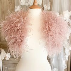 a white mannequin with pink feathers on it