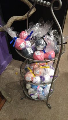 three tiered metal rack filled with lots of different colored balls and plastic wrappers