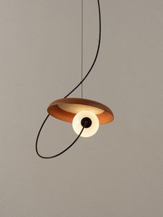 a wooden light fixture hanging from a ceiling with two lights on each side and an object in the middle