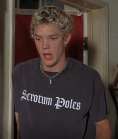 a young man wearing a black shirt with the word scrotum police on it