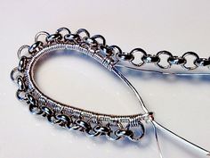 a pair of silver bracelets sitting on top of a white table next to each other