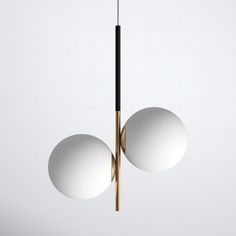 two white balls hanging from a wooden pole with one black and one white ball in the middle