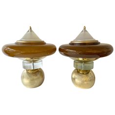 two brass and glass knobs are shown against a white background, one has a brown dome on the top