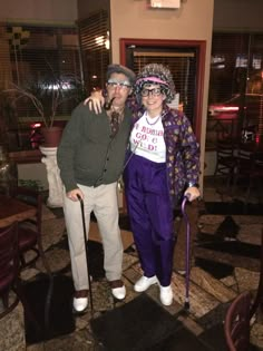 a man and woman dressed up for halloween in a restaurant with an old fashioned cane