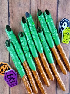 some green and brown sticks are on a wooden table with halloween stickers around them