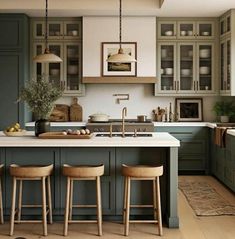 an image of a kitchen setting with green cabinets and stools on the countertop