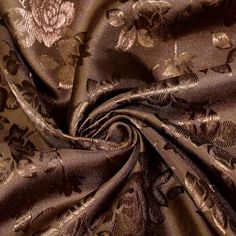 a close up view of a fabric with flowers and leaves on it, in brown