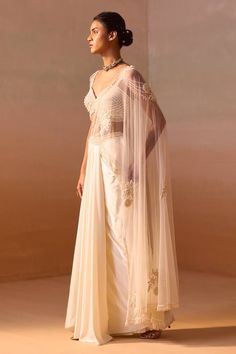 Ivory pre-draped saree crafted in net with pearl rosette embroidery and tassel embellishments. Paired with a pearl embroidered bustier with pearl tassel embellishments. - Aza Fashions Elegant Wedding Sets With Draped Sleeves, Elegant Draped Wedding Sets, Luxury Pearl Embroidered Pre-draped Saree For Wedding, Traditional Wedding Pre-draped Saree With Draped Sleeves, Pre-draped Set With Sheer Dupatta For Reception, Festive Wedding Saree With Draped Sleeves, Draped Saree With Dupatta For Wedding, Floor-length Saree With Draped Sleeves For Wedding, Wedding Saree With Draped Sleeves And Floor-length