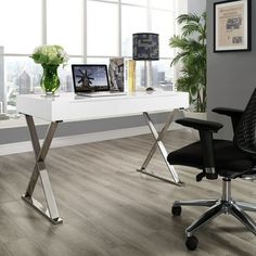 a white desk with a laptop on it in front of a large window and potted plant