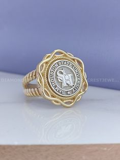 a gold ring with an emblem on it