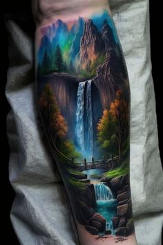 a man's arm with a painting on it and waterfall in the middle, surrounded by mountains