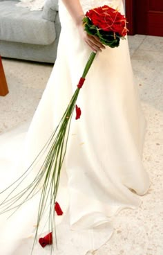 a woman in a wedding dress holding a bouquet of flowers