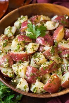 a wooden bowl filled with potatoes and herbs