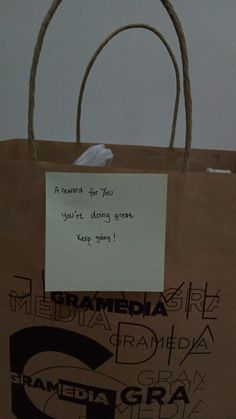 a brown paper bag with writing on it and a note attached to the handle that says, thank you're doing great keep going