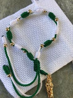 "Handmade, adjustable green and white st. Judas Thaddeus plated gold beads bracelet. Material: nylon string/green and white #18, #9 plated gold 14k beads 4mm St. Judas Thaddeus plated gold pendant 2.50cm Bracelet made for unisex adults,minimum slide lock from 7\" inches to 8.5\" inches ; perfect for a gift!" Adjustable Green Bracelets With Gold Beads, Handmade Adjustable Green Rosary Bracelet, Green Handmade Adjustable Rosary Bracelet, Adjustable Handmade Green Rosary Bracelet, San Judas Bracelet, Mexican Bracelet Ideas, Mexican Beaded Jewelry, Mexican Bracelets Handmade, Bracelets From Mexico