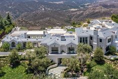 an aerial view of a large house with mountains in the background