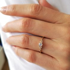 a woman's hand with a diamond ring on top of her finger and an engagement band