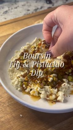 a person is picking up food from a white plate on a table with the words bourbon fig & pistachio dip