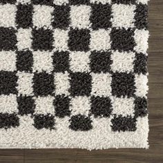 a black and white rug on top of a wooden floor with an area rug in the middle