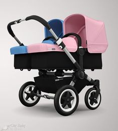 two baby strollers, one pink and one blue, side by side on a gray background