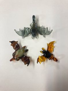 "Flameworked borosilicate glass bats with loops. Each hangs upside down with wings outstretched from a loop at their feet with an inner diameter of ~3mm. The \"primary color\" is the color of the body and the \"secondary color\" is the color of the wings." Glass Blowing Art, Glass Trinkets, Resin Art Ideas, Gold Resin Coasters, Resin Art Diy, Glass Accessories, Glass Craft, Resin Coasters, Glass Charms