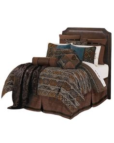 a bed with brown and blue comforters on it's side, along with two pillows