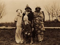 an old black and white photo of three people dressed up as clowns, one with a dog on his head