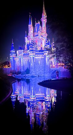 the castle is lit up with colorful lights