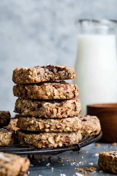 a stack of oatmeal cookies next to a glass of milk