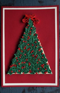 a christmas tree made out of paper on a red card with white and green trim