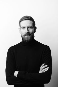 a black and white photo of a man with his arms crossed