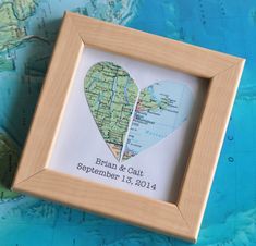 a wooden frame with a map in the shape of a heart and a quote about love