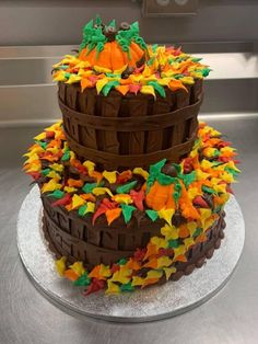 a three tiered cake decorated with fall leaves