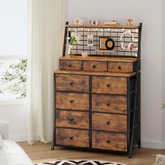 a wooden dresser sitting in a living room next to a window